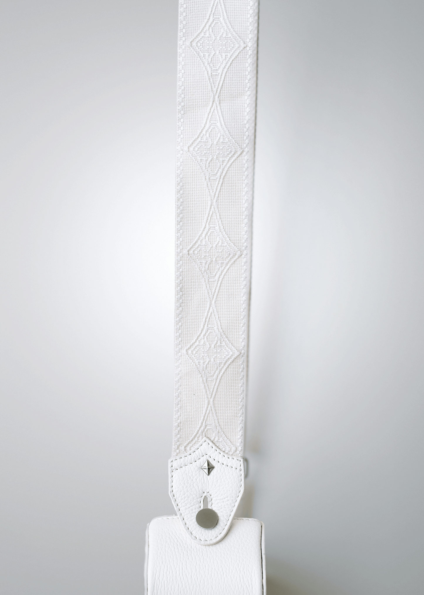 Close-up of Mary and Shelley signature logo cotton jacquard guitar strap in Ivory, shown with Strapbolt™ hardware and starburst stud.