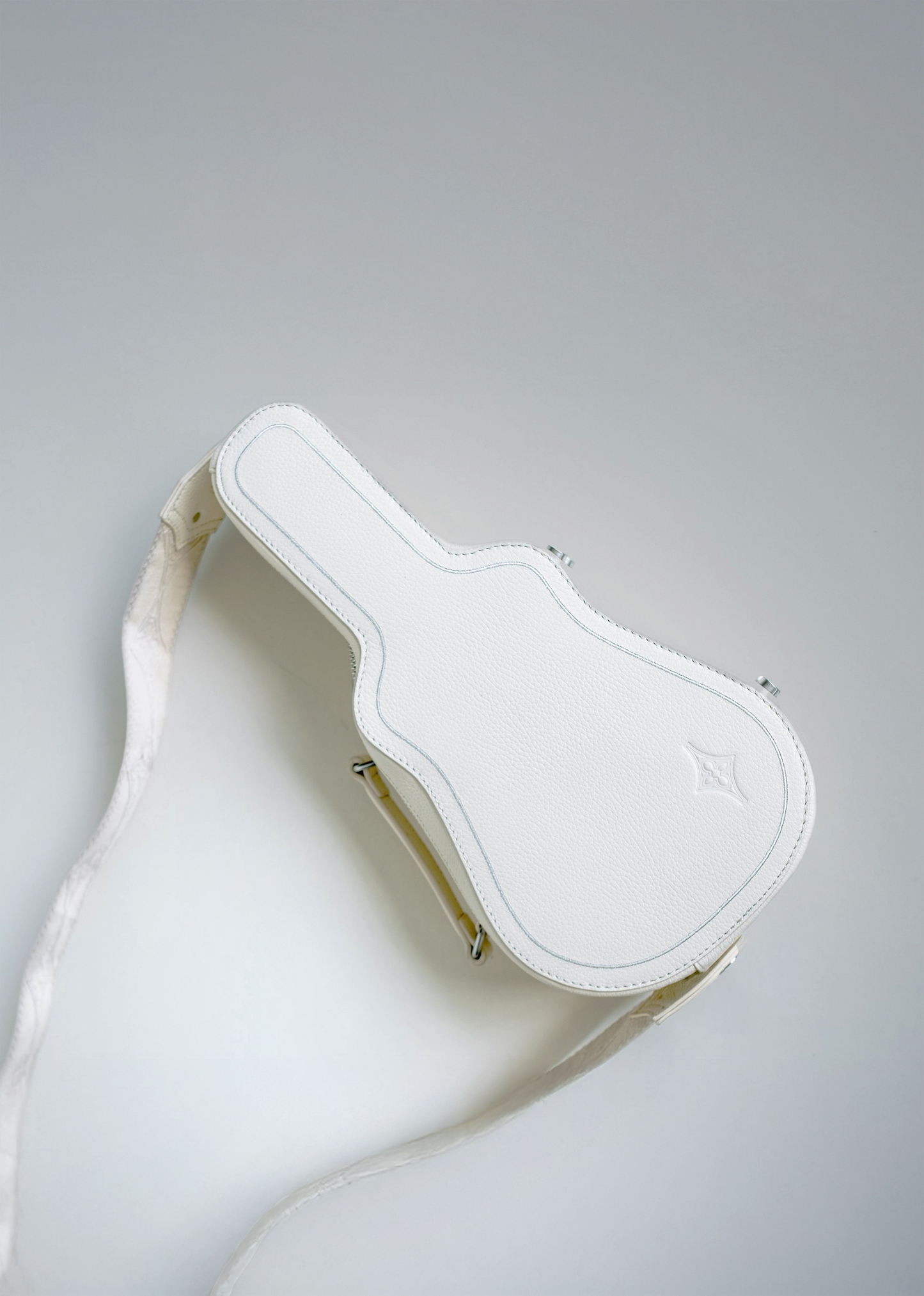 White (Ivory) Mary and Shelley Ritual Crossbody Bag with guitar case silhouette, embossed logo, and adjustable strap shown laid flat.