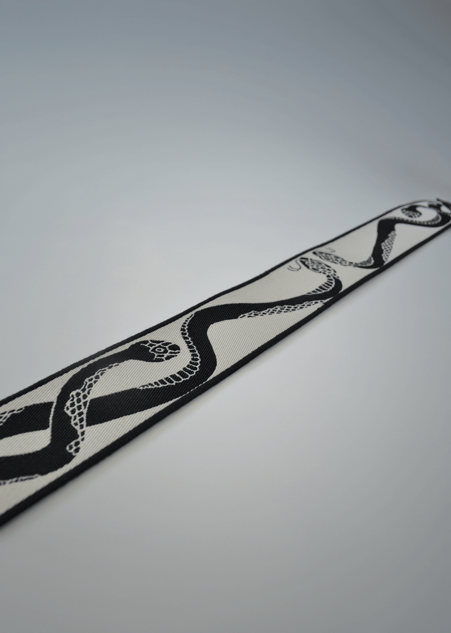Ivory side of reversible snake jacquard guitar strap by Mary and Shelley, close-up detail.