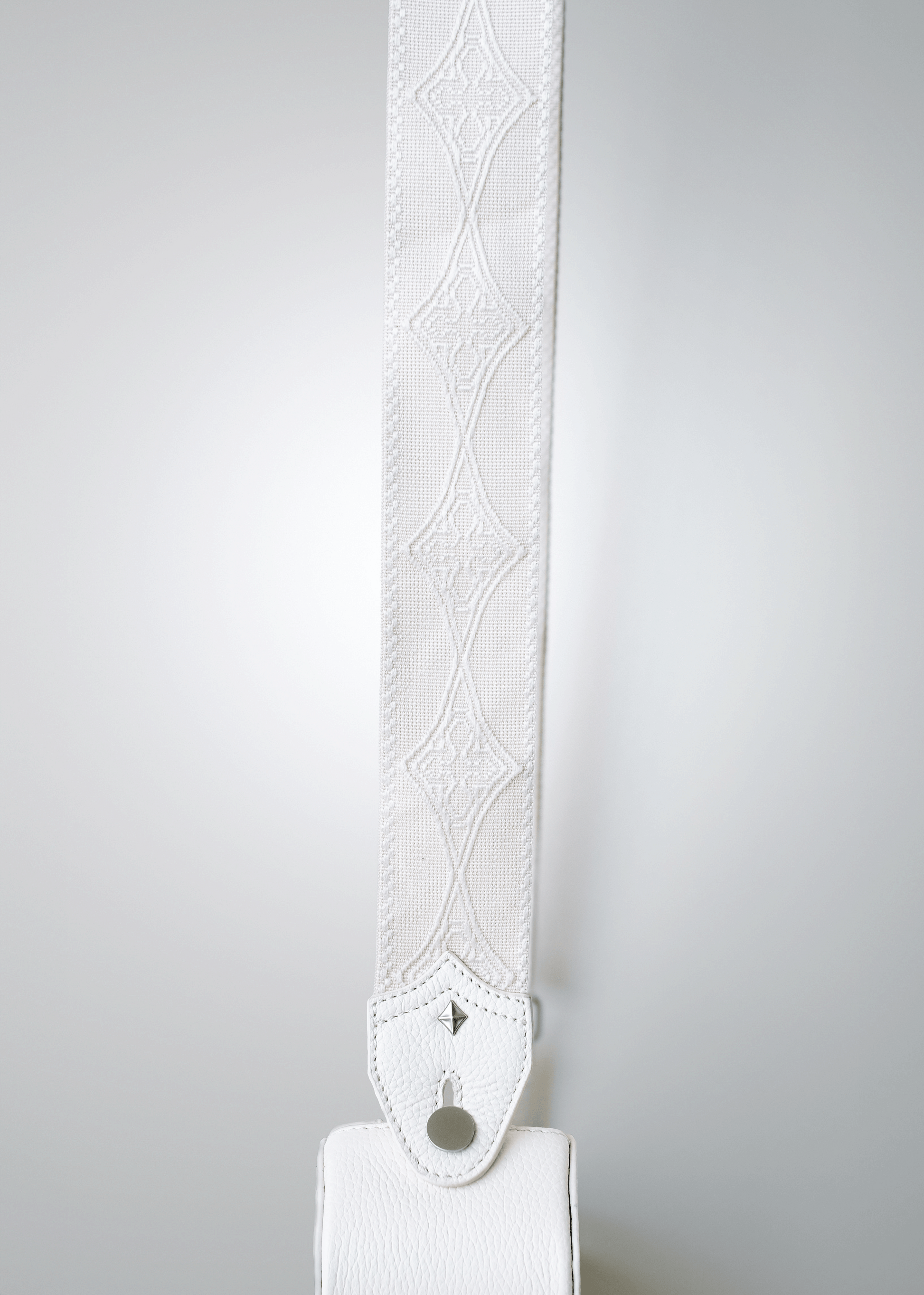 Close-up of Mary and Shelley signature logo cotton jacquard guitar strap in Ivory, shown with Strapbolt™ hardware and starburst stud.