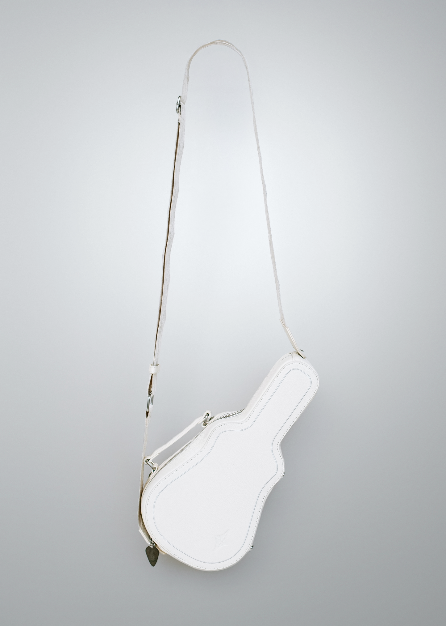 White Mary and Shelley Ritual Crossbody Bag with adjustable cotton jacquard strap, guitar pick zipper pull, shown fully extended to display guitar case silhouette.